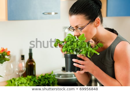 Woman Smelling A Herb Pot Foto d'archivio © Kzenon