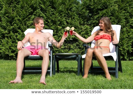 Stock fotó: Couple Sunbathing In Back Yard And Toasting