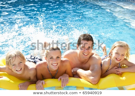 Stockfoto: Happy Young Family Having Fun Together At The Swimming Pool