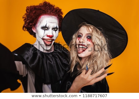 Foto d'archivio: Photo Of Witch Woman And Clown Man Wearing Black Costume And Hal