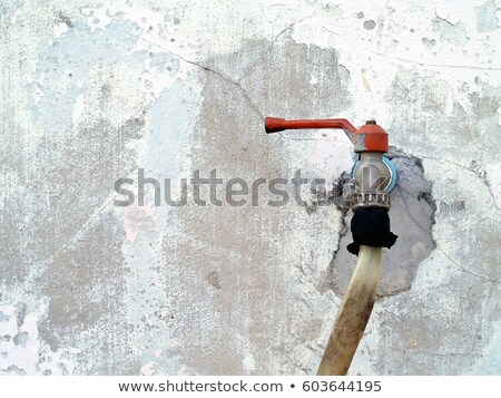 Foto stock: Rusty Metal Embedded In A Worn Dirty Concrete Wall