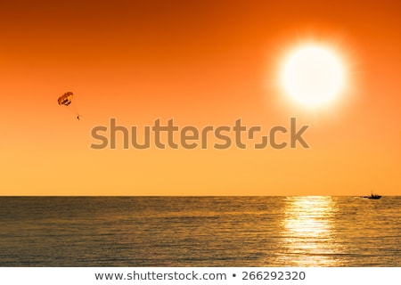 Stockfoto: Sepia Silhouette Of Parasailing Man On The Sunset