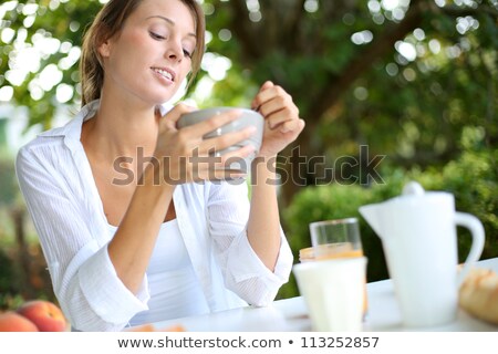 Stock photo: Young Caucasian Woman Eating Breakfast In Garden