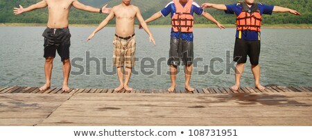 Stockfoto: Four Peoples Legs On A Beach
