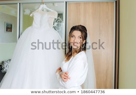 Foto d'archivio: A Beautiful Young Girl In A White Robe Is Standing Near The Shelter And Flips Through A Red Folder W