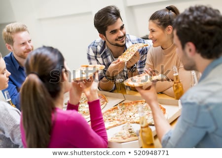 Foto d'archivio: Young People Eating Pizza And Drinking Cider In The Modern Inter