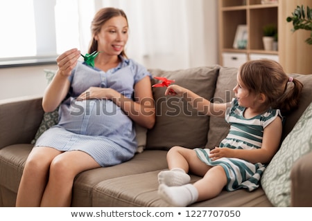 Foto stock: Pregnant Mother And Daughter With Crane Origami