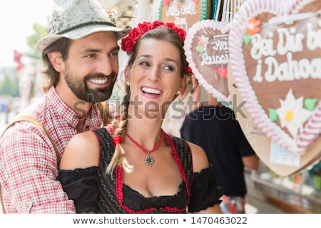 Foto stock: Couple Buying Gingerbread Hearts Of Bavarian Fair