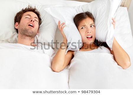Foto stock: Unhappy Woman In Bed With Snoring Sleeping Man