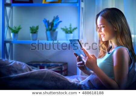 Stock fotó: Young Woman Using Her Tablet At Night