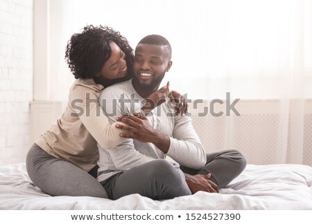 Сток-фото: Happy Young Couple Sitting On The Bed At Bedroom