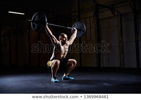 Foto stock: Shirtless Muscular Man Lifting Barbell In Gym