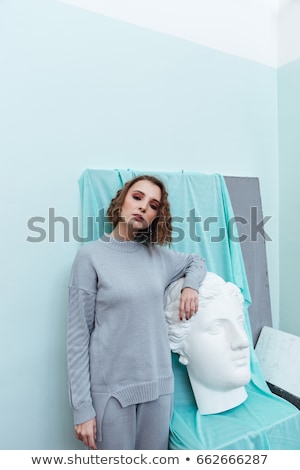 Foto d'archivio: Young Woman Leaning Against Art Sculpture