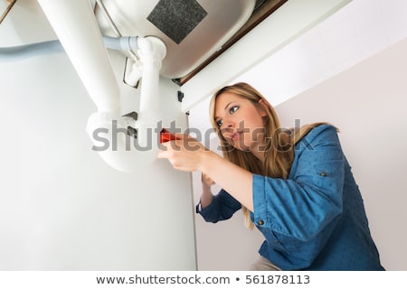 Foto stock: Woman Repairing Sink Pipe With Adjustable Wrench