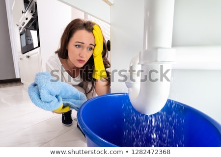 Zdjęcia stock: Woman Looking At Sink Pipe Leakage In Kitchen