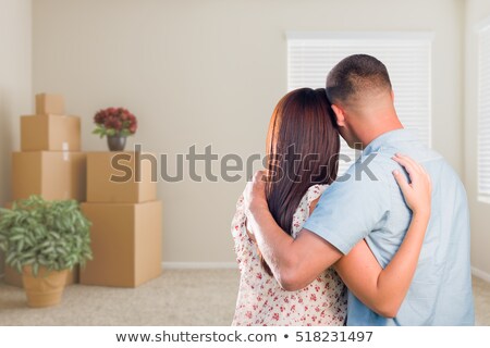 Сток-фото: Young Military Couple Looking At Empty Room Of New House