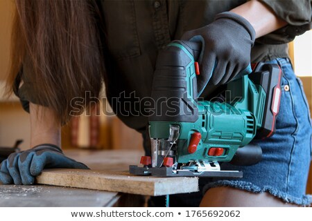 Stock fotó: Woman Carpenter Using A Jigsaw