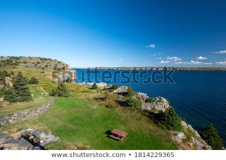 Stock photo: Red And Blue Bench At The Edge Of A Cliff