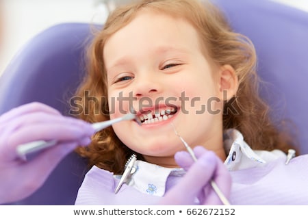 Foto stock: Pediatric Dentist Examining A Patients Teeth In The Dentists Cha