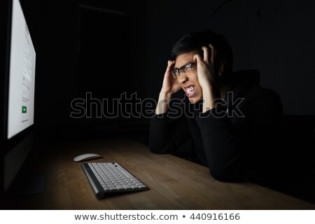 Stock photo: Mad Irritated Man Working With Computer In Dark Room
