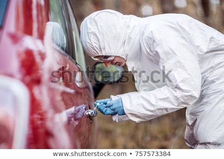 Foto stock: Criminalist Collecting Evidence At Crime Scene