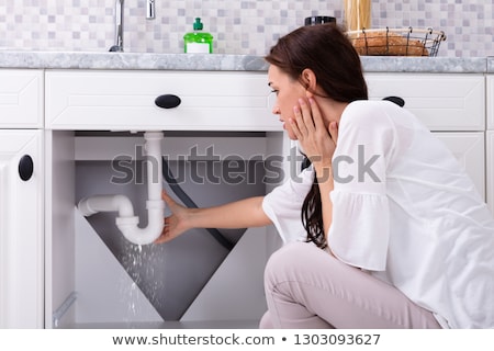ストックフォト: Woman Trying To Stop Water Leakage From Sink Pipe