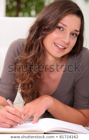 Stock foto: Long Haired Girl Writing In A Hardback Notebook