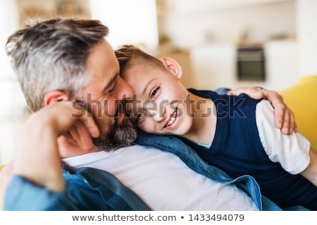 Сток-фото: Portrait Of Father And Son Relaxing On Sofa Together