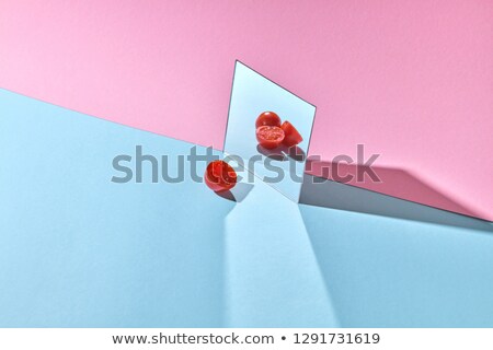 A Ripe Tomato Is Reflected In A Mirror On A Double Pink Blue Cardboard Background With Space For Tex Сток-фото © artjazz