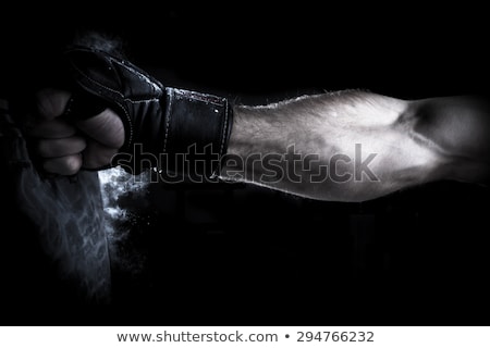 Foto stock: Male Boxer Boxing In Punching Bag With Dramatic Edgy Lighting In A Dark Studio