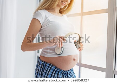 Сток-фото: Close Up Of Pregnant Woman Belly With Headphones