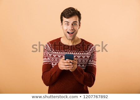 Zdjęcia stock: Image Of Happy Man 20s With Stubble Wearing Knitted Sweater Scre