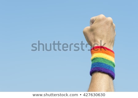Foto stock: Man With Rainbow Flag And Gay Pride Wristbands