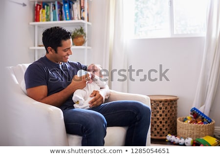 Stock photo: Close Up Of Father Feeding Baby From Bottle