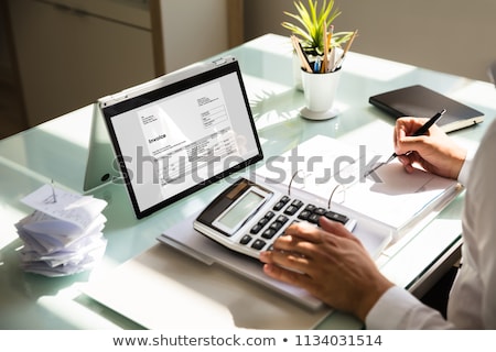 ストックフォト: Businessmans Hands Working On Invoice On Laptop