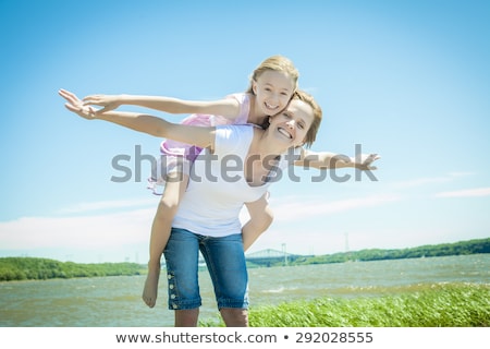 Сток-фото: Young Girl Hugging Her Mother Piggyback Style