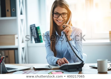 Stock fotó: Young Elegant Businesswoman Looking At You With Toothy Smile While Typing