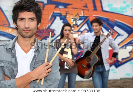 Foto stock: Woman With Guitar In Front Of Painted Wall