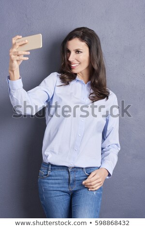 Foto d'archivio: Smiling Brunette Leaning Against The Wall While Posing