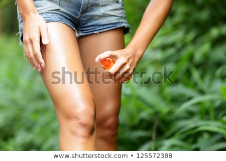 Foto d'archivio: Woman Spraying Insect Repellent On Skin Outdoor