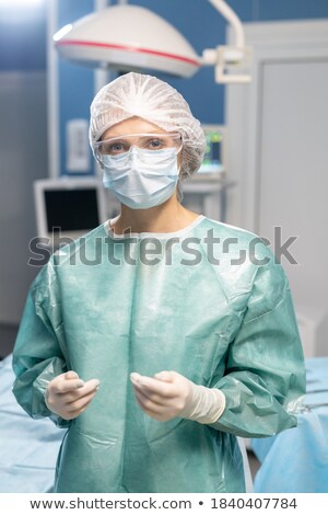 Stock photo: Paramedic In Blue Workwear And Gloves Looking For Medicine In First Aid Kit