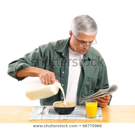 Foto stock: Man Reading His Newspaper Over Breakfast