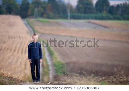 Foto stock: Young Boy Standing In Green Grassy Field