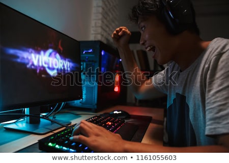 Stockfoto: Asian Happy Gamer Boy Rejoicing While Playing Video Games On Sma