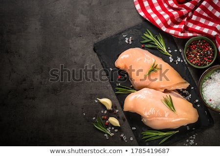 [[stock_photo]]: Fresh Raw Organic Chicken Fillet Breast On Black Stone Board With Meat Hatchets And Spices With Herb