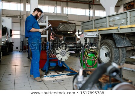 Foto stock: Young Serious Worker Of Automobile Repair Service Reading Instructions