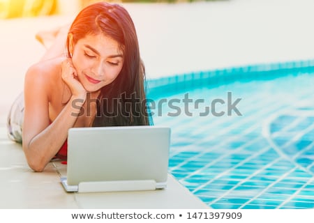 Foto stock: Young Woman In Bikini Using Laptop