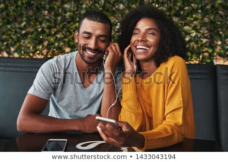 Foto stock: Happy Woman In Earphones Listening To Music From Mobile Phone