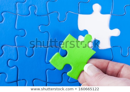 [[stock_photo]]: Womans Hand Placing Missing Piece In Jigsaw Puzzle Signifying