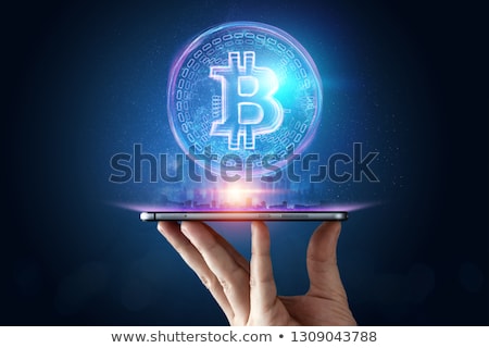 Foto stock: Hand With Smartphone And Bitcoin Hologram